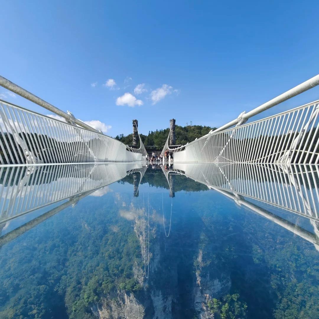 Take the world's longest cable car to the summit of Tianmen Mountain. Walk on the thrilling Glass Skywalk, overlooking the 99-bend "Roads to Heaven," feeling your heartbeat during this cloud-walking experience. In the afternoon, drive to Furong Town - a thousand-year-old ancient town perched on a waterfall. The nighttime waterfall light show presents a visual and auditory feast.
