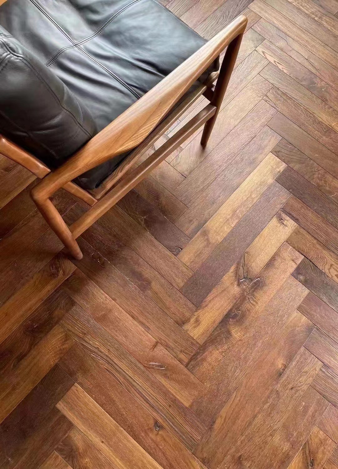 Close-up of brushed smoked oak wood grain texture with UV lacquer surface finish, 14/3×90×600mm engineered herringbone plank flooring detail