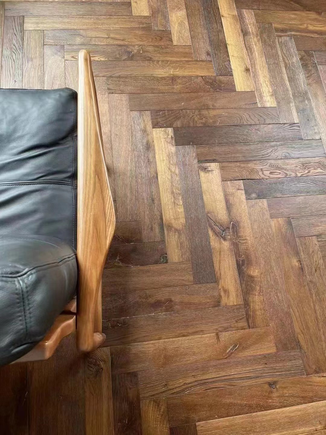 Close-up of brushed smoked oak wood grain texture with UV lacquer surface finish, 14/3×90×600mm engineered herringbone plank flooring detail