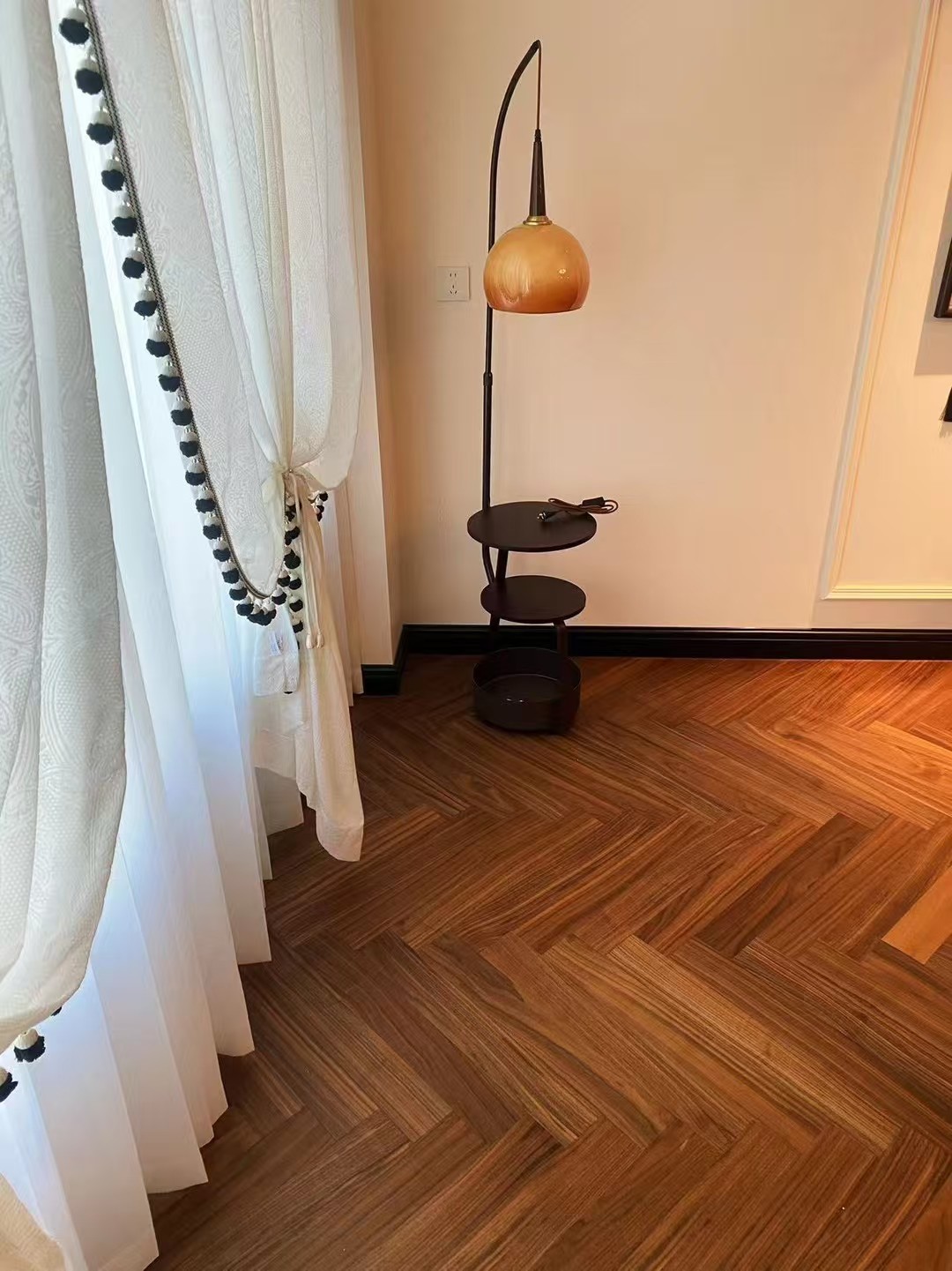 Warm walnut herringbone engineered wood flooring installed in a mid-century modern Amsterdam apartment, featuring elegant oak grain, smooth UV lacquer finish, and retro-inspired interior styling with natural daylight.
