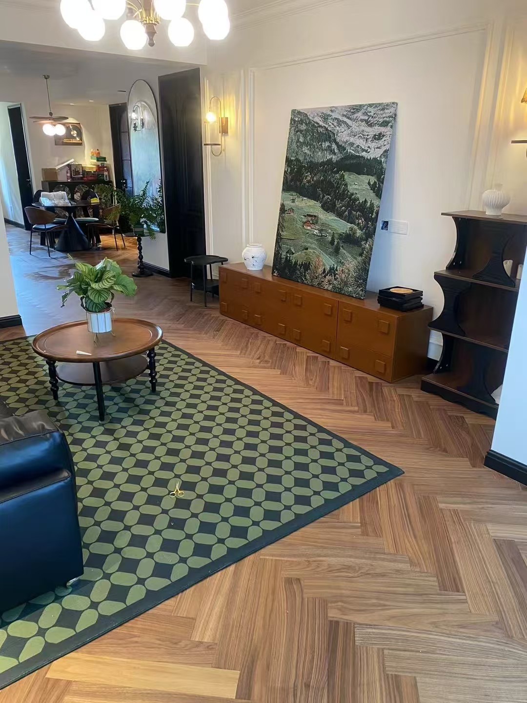 Warm walnut herringbone engineered wood flooring installed in a mid-century modern Amsterdam apartment, featuring elegant oak grain, smooth UV lacquer finish, and retro-inspired interior styling with natural daylight.