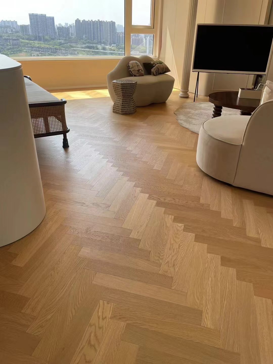 Light natural oak herringbone engineered wood flooring installed in a luxury Sydney Harbour condominium with modern French interior styling and bright natural lighting.