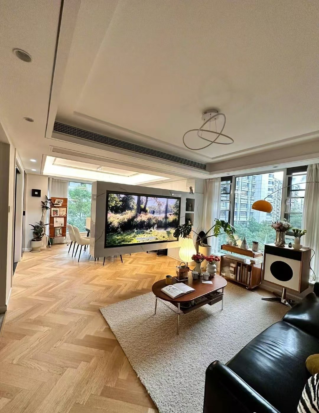 Wide herringbone engineered oak flooring installed in a modern eclectic apartment in Shanghai with open-plan interior design and natural lighting.