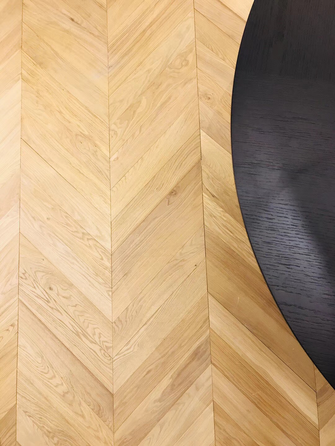 Close-up of brushed warm natural oak wood grain texture with UV lacquer surface finish, 14/3×90×510mm engineered chevron plank flooring detail