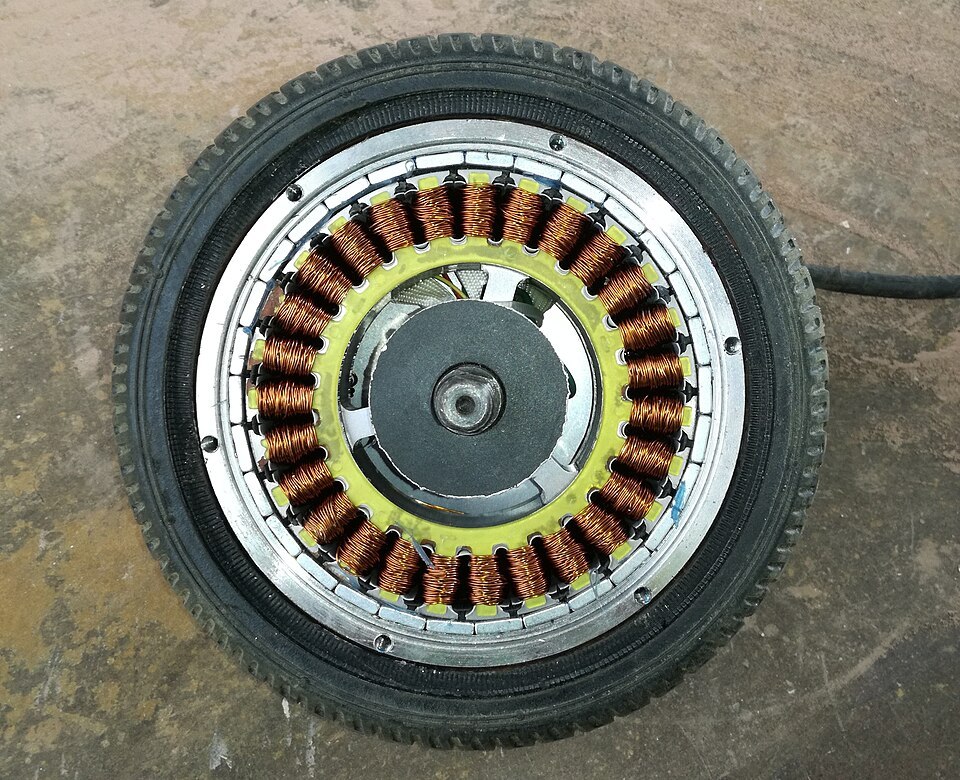 Brushless hub motor of an electric scooter with its side panel removed, exposing the stator and copper windings inside