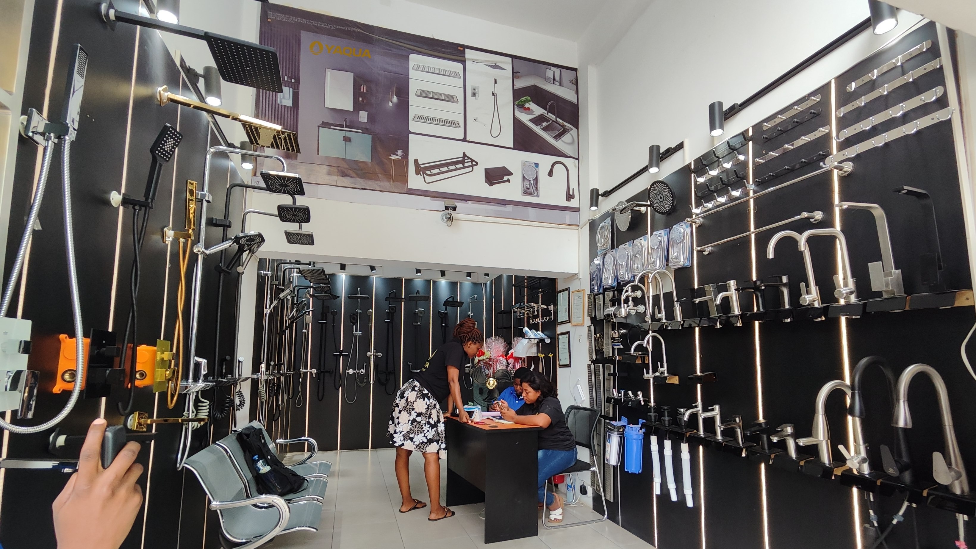 Hardware and plumbing shop interior with wall displays of basin taps, shower heads and shower sets