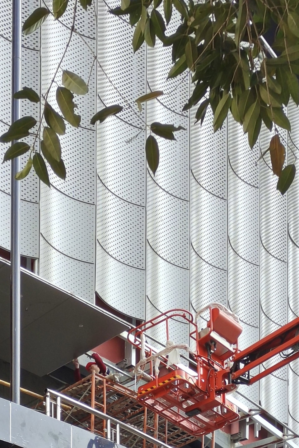Perforated stainless steel facade panels installed on a cultural building during construction