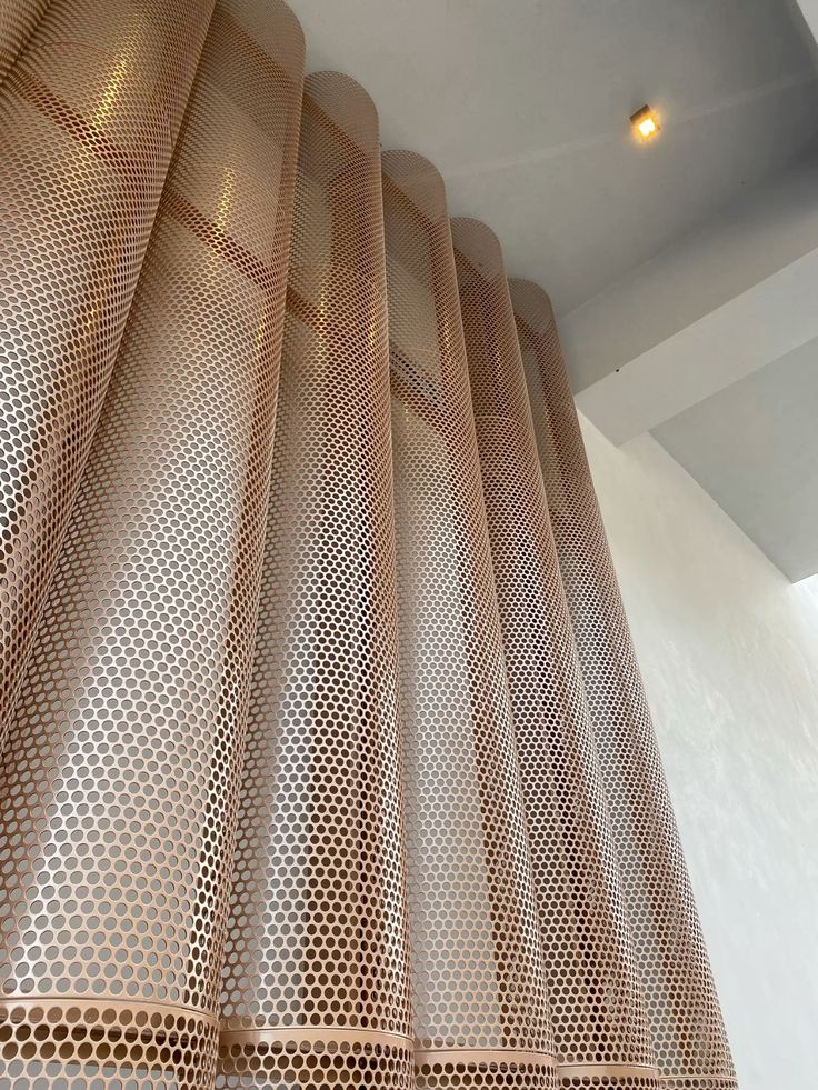 Curved perforated stainless steel screen panels used as an interior partition