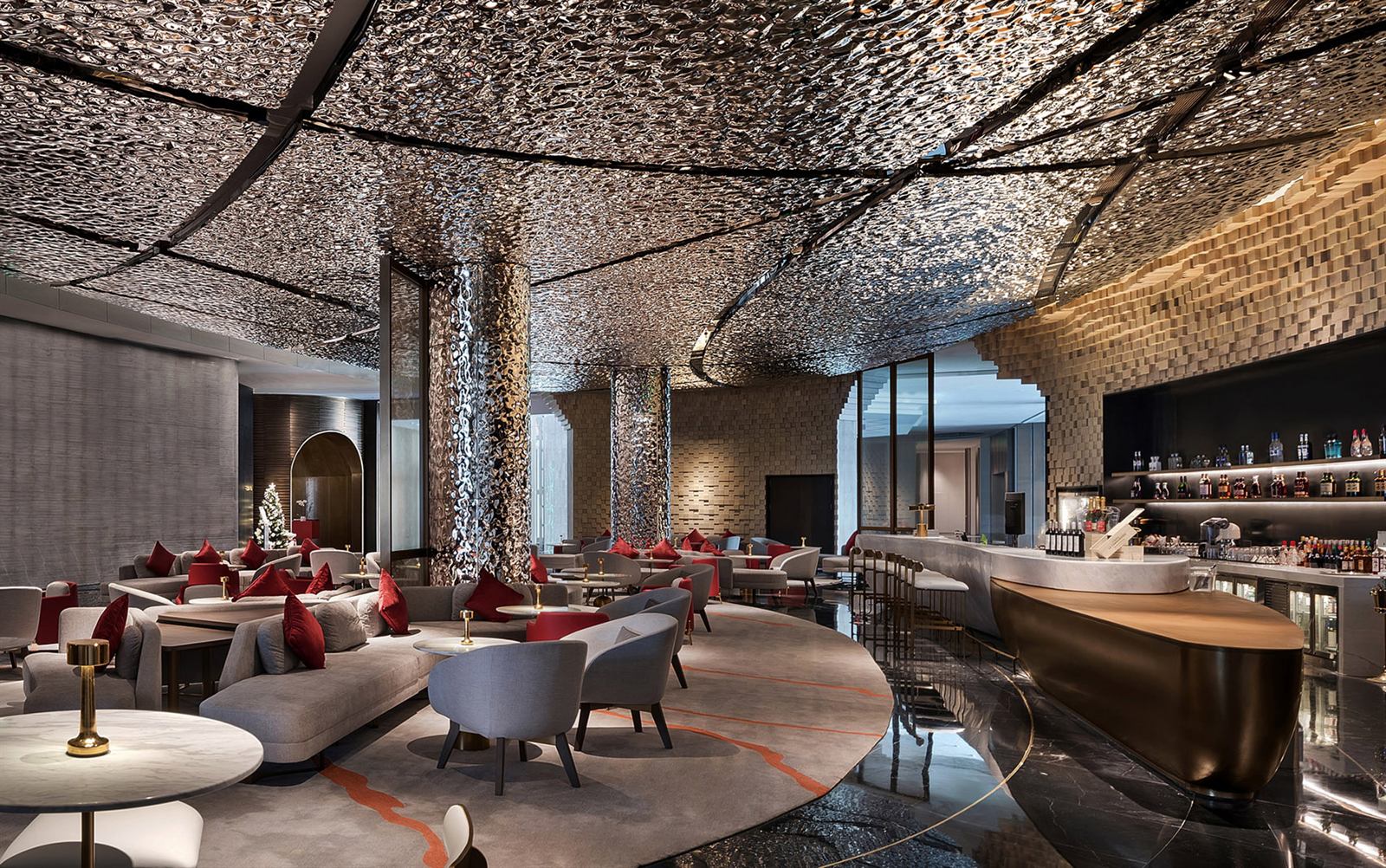 Warm gold metal ceiling and wall surfaces in a luxury hotel lobby