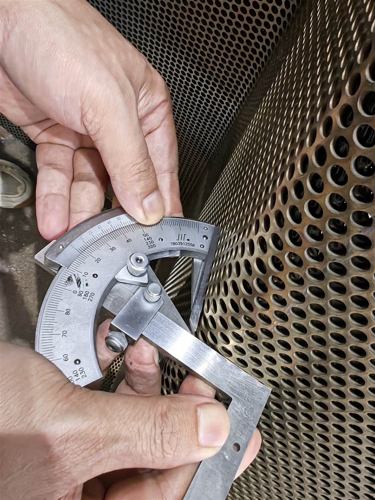 Caliper measurement taken against a stainless steel component during inspection