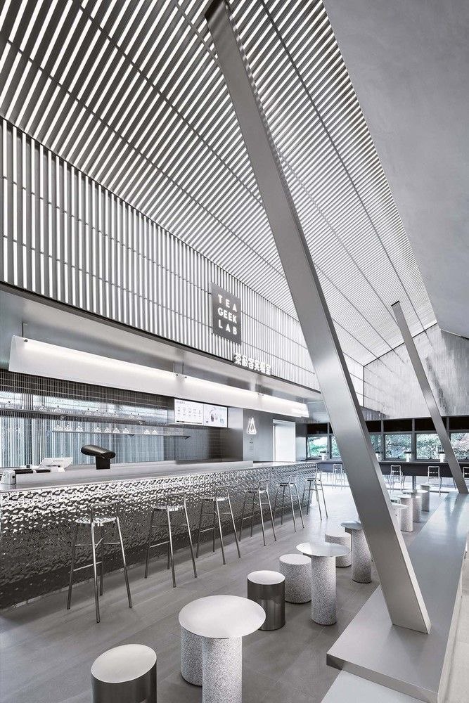 Parallel stainless steel baffle ceiling with regular cross members for directional rhythm