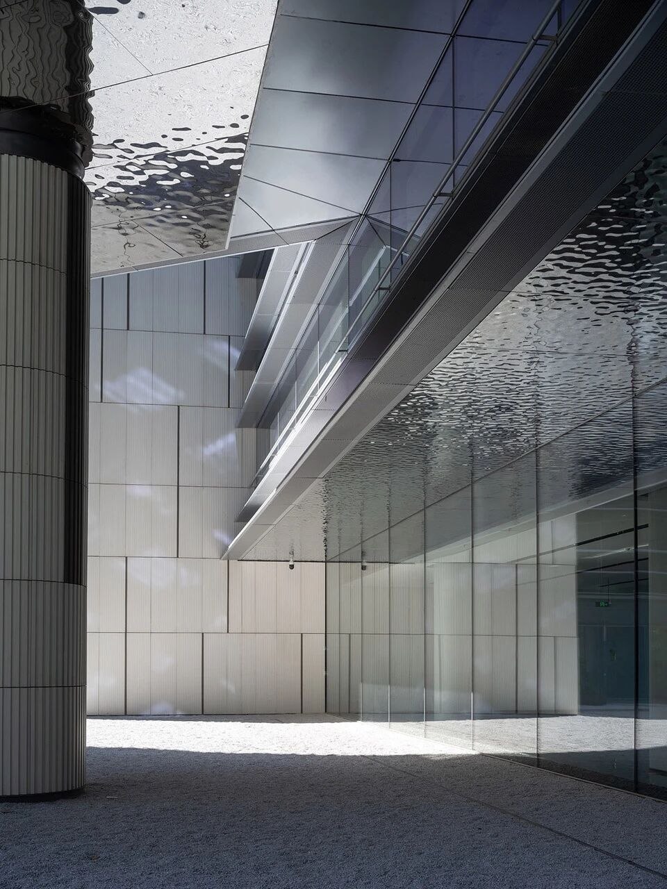 Water ripple stainless steel canopy at a building threshold with fluid reflections