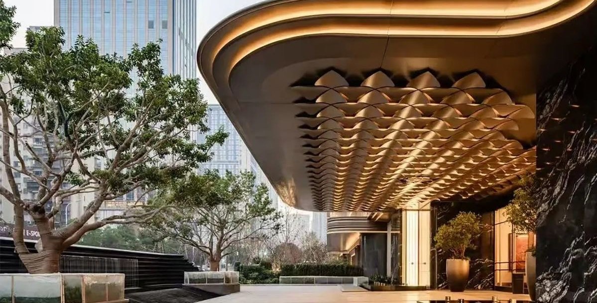 Scalloped embossed stainless steel canopy soffit above an entrance