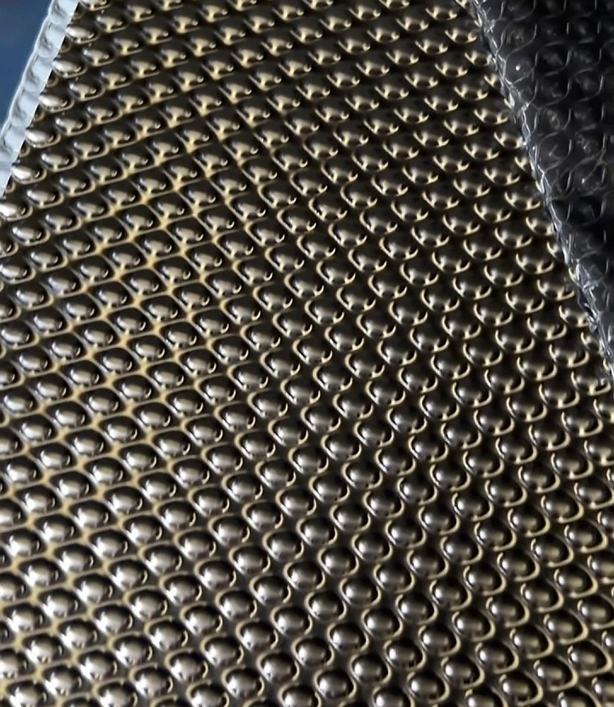 Embossed stainless steel sheet leaving the line with its protective film lifting