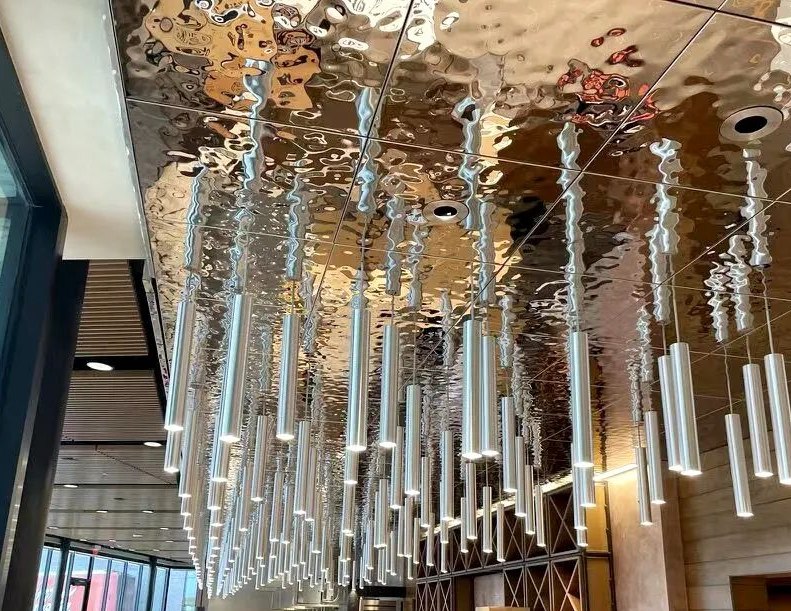 Water ripple stainless steel ceiling bringing fluid reflection to a large overhead surface