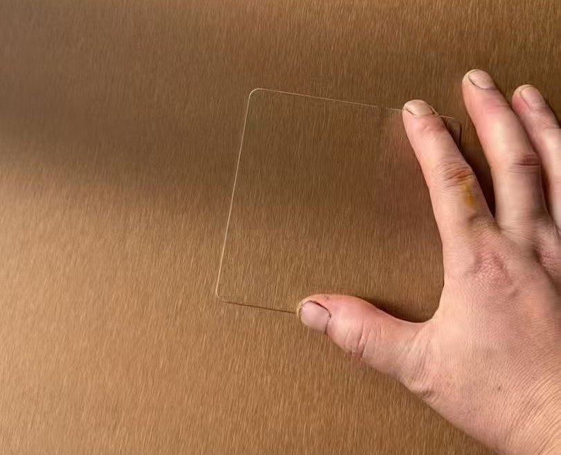 Hand checking a physical stainless steel sample panel before project approval