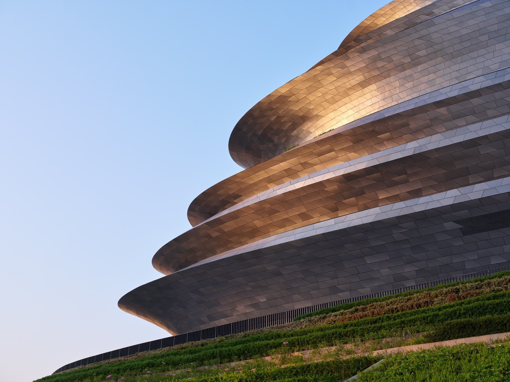 PVD coloured stainless steel roof bands flowing across a museum facade