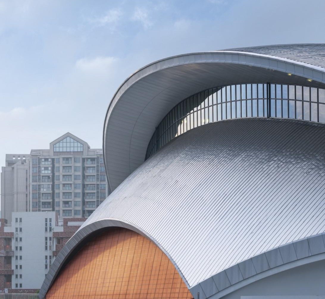 Formed stainless steel roof element installed over a curved building edge