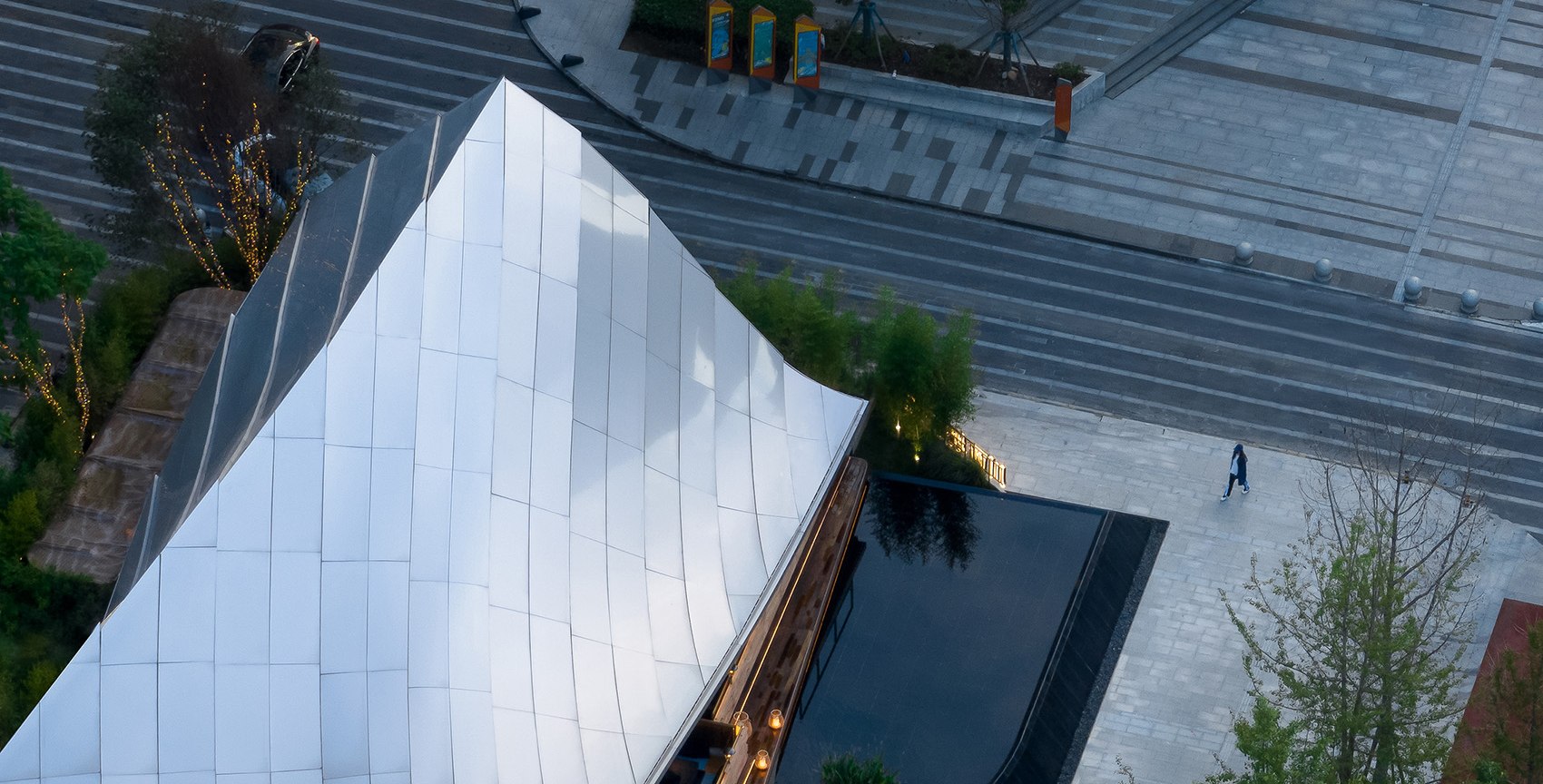 Folded stainless steel roof defining a distinctive landmark building