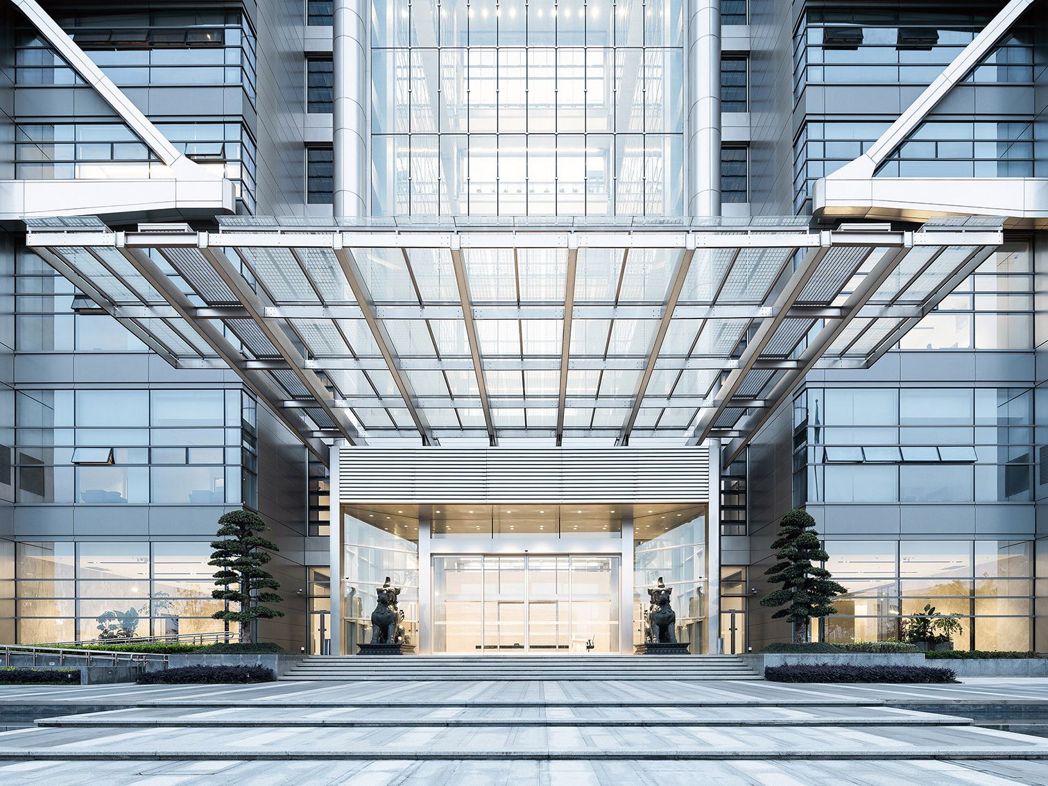 Symmetrical flat portal entrance framed by clean stainless steel cladding