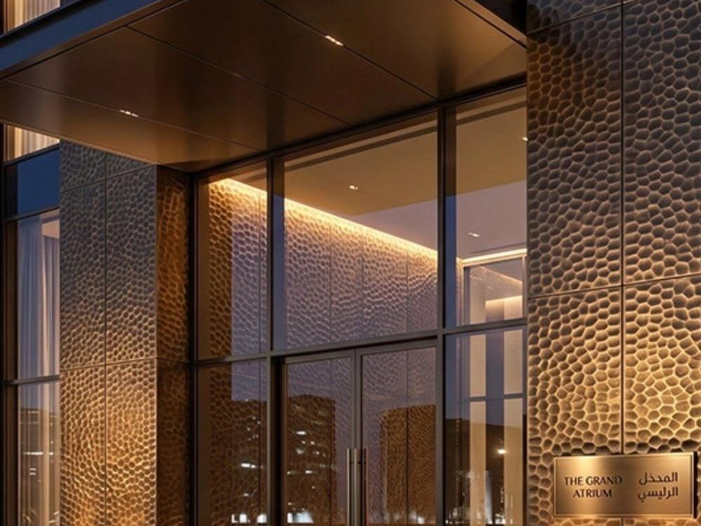 Champagne PVD stainless steel canopy soffit glowing above an entrance