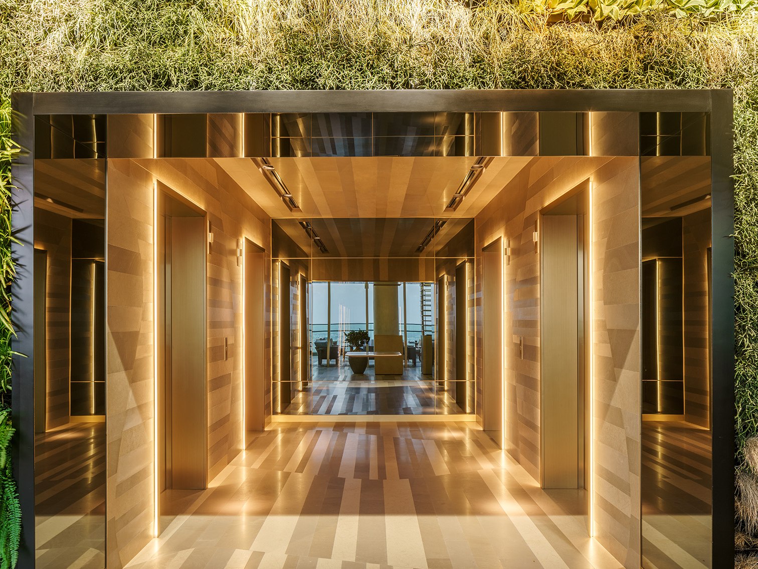 Gold stainless steel feature wall framing an opening in a restaurant interior