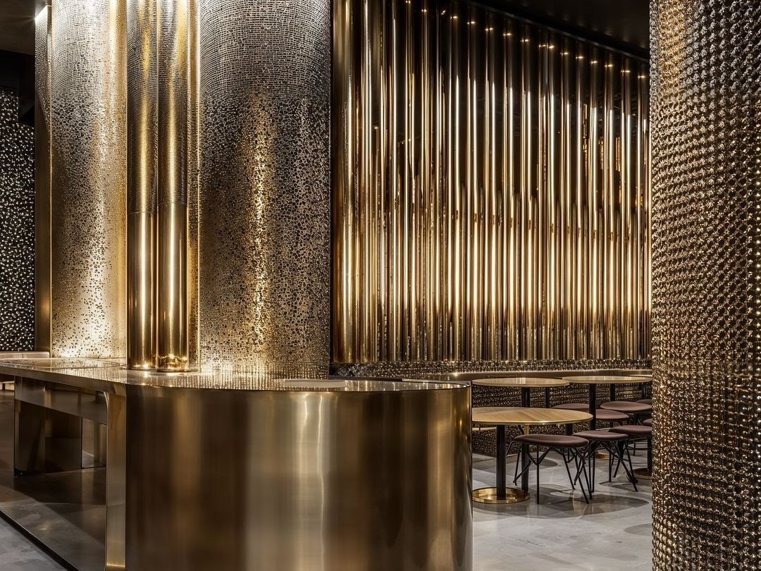 Bronze PVD stainless steel fluted feature wall in a hospitality interior