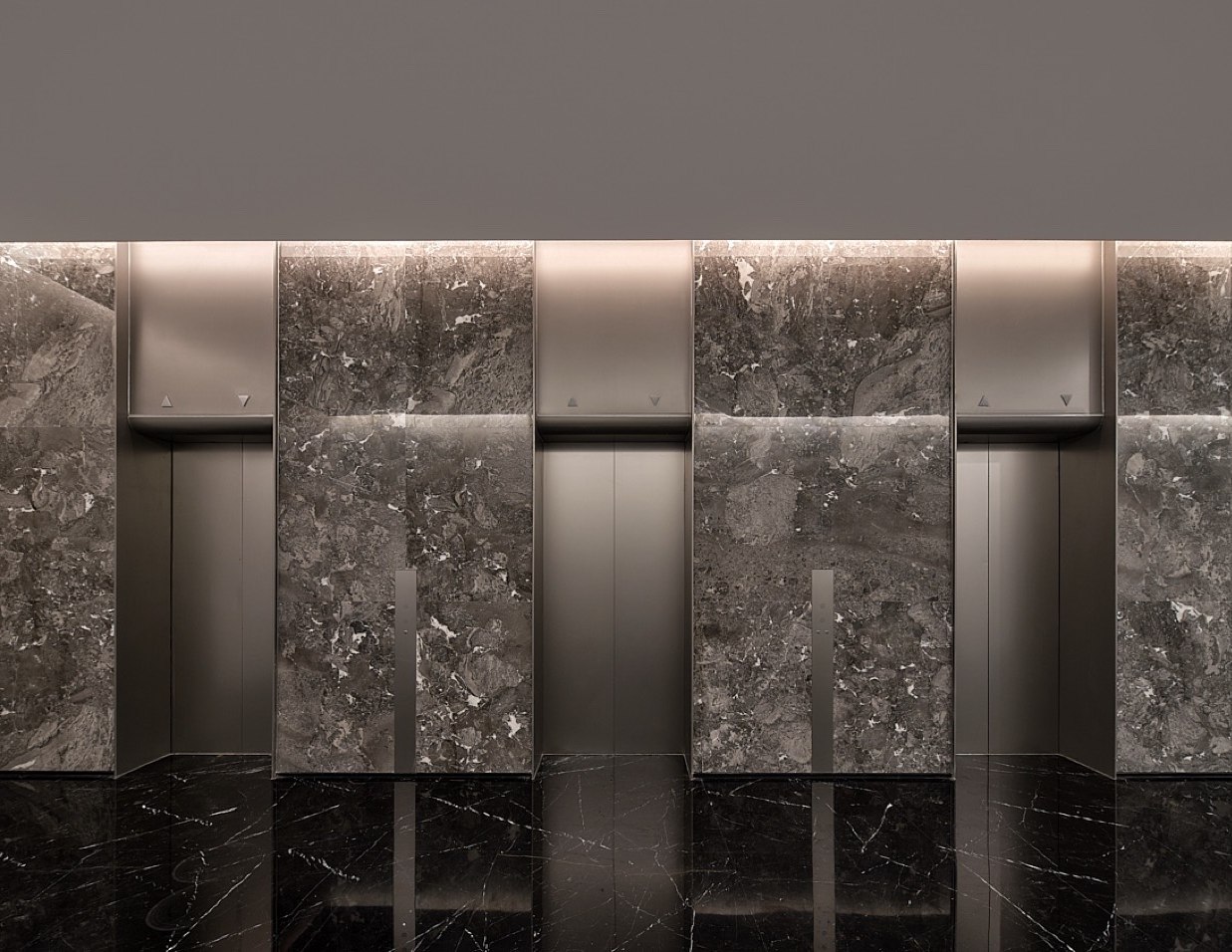 Cool stone and stainless steel elevator lobby in a corporate tower