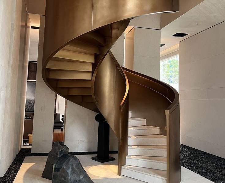 Bespoke PVD bronze stainless steel spiral staircase fabricated as a continuous metal ribbon