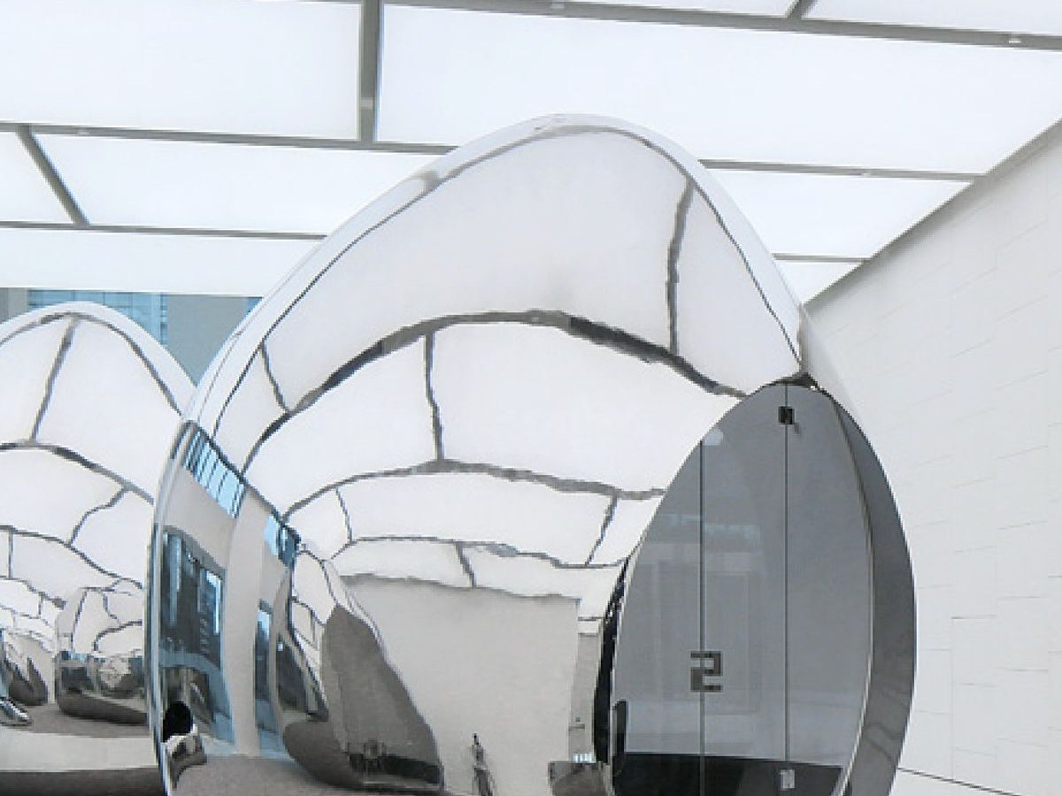 Mirror-polished sculptural stainless steel form reflecting its surroundings