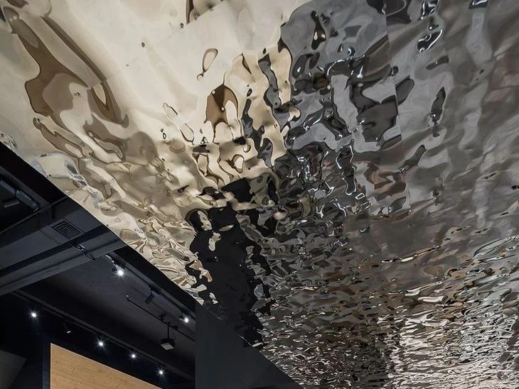 Water ripple stainless steel surface turning light into textured reflection