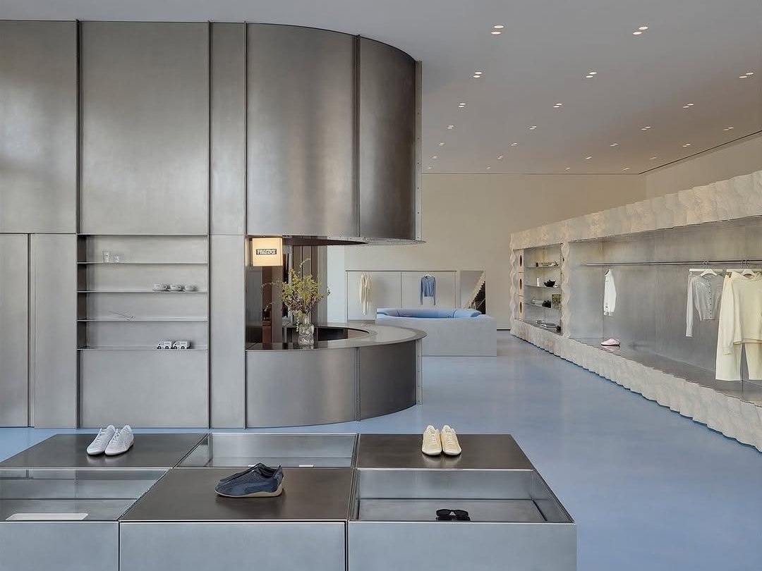 Brushed stainless steel display structure with directional grain and clean geometry
