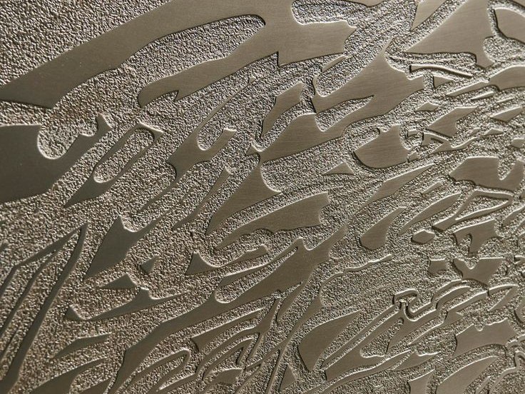 Etched decorative pattern developed across a stainless steel surface