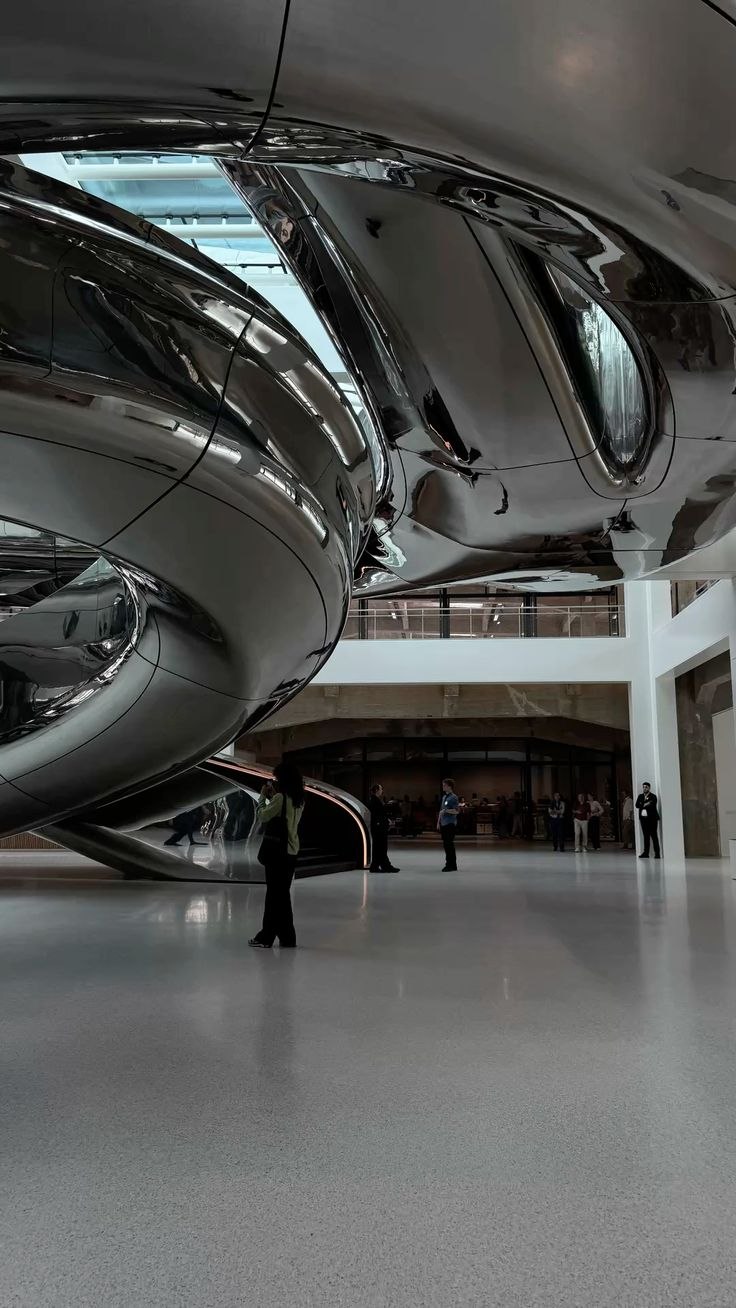 Formed mirror-polished stainless steel creating changing reflections across custom architectural geometry