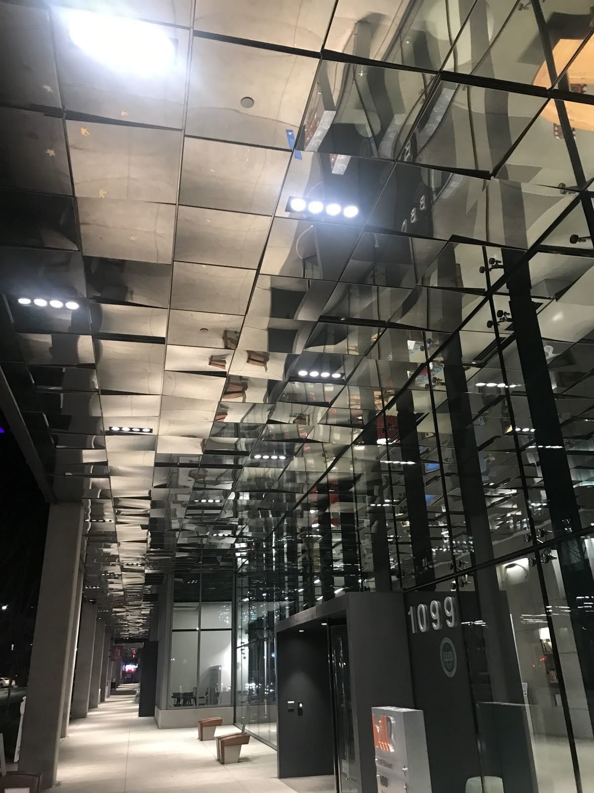 Mirror-polished stainless steel panels forming a reflective ceiling in a commercial interior