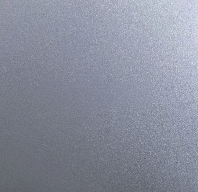 Bead-blasted stainless steel under soft daylight, reading as a calm and uniform metallic plane
