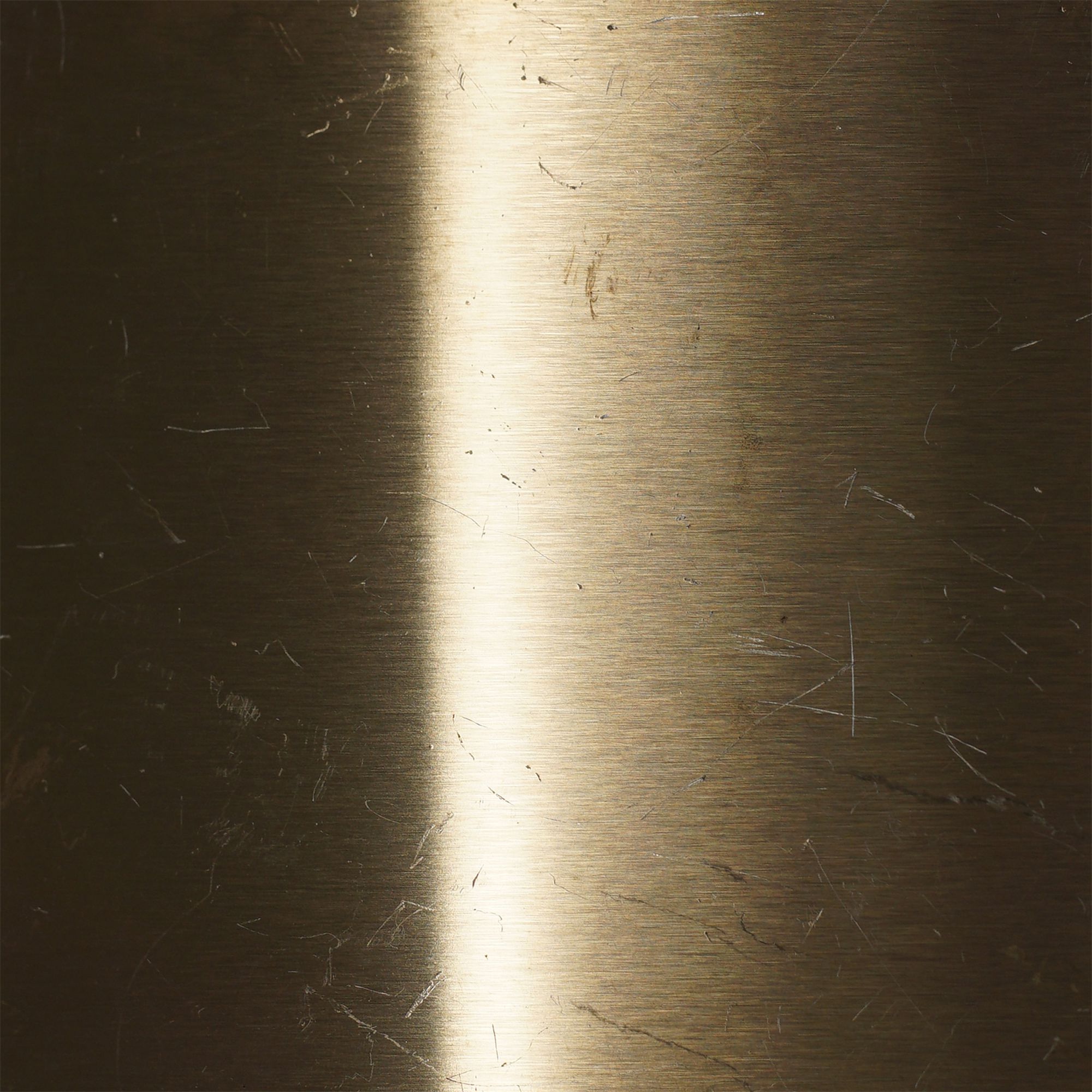 Champagne gold stainless steel under directional light that emphasises the grain beneath the color