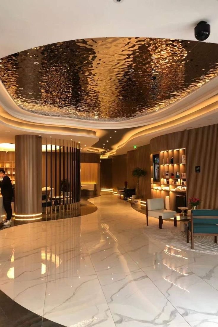 Gold-toned metallic ceiling giving architectural rhythm to a hospitality interior