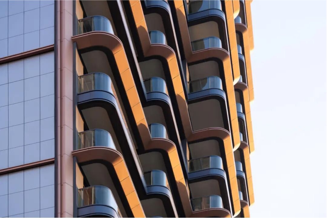 Warm bronze-toned PVD stainless steel architecture under soft light