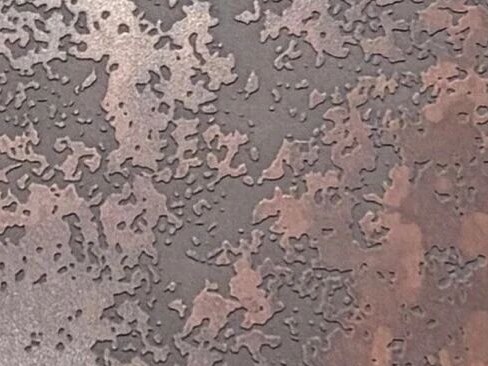 Close range detail of an antique patina surface where copper veining becomes visible