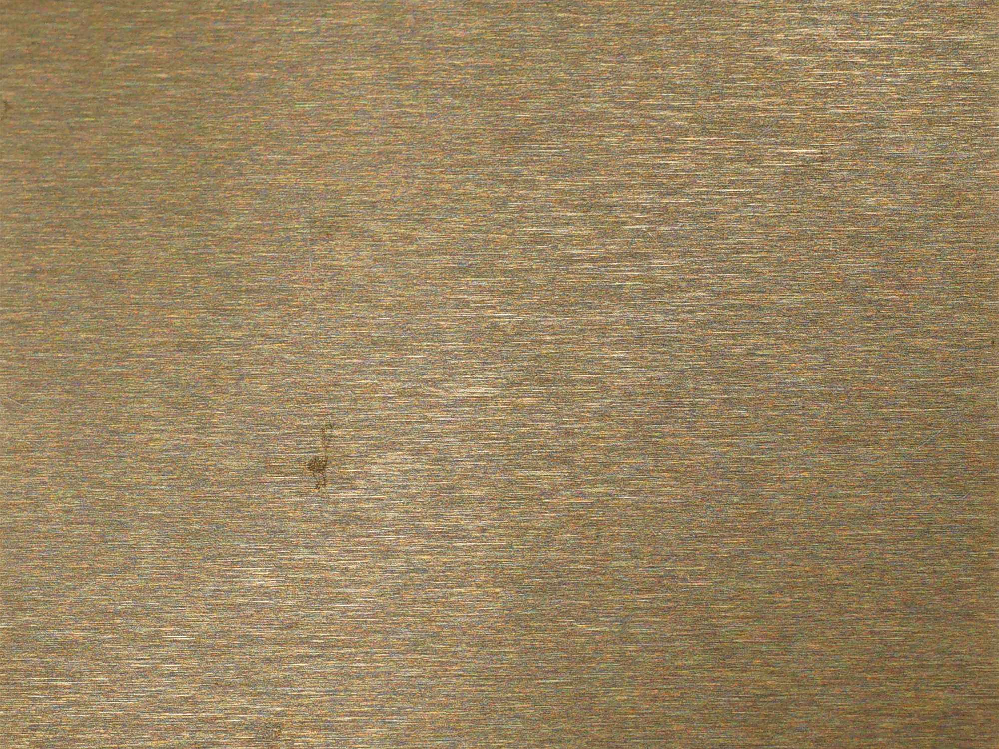 A champagne gold colour coated stainless steel surface with a hairline grain