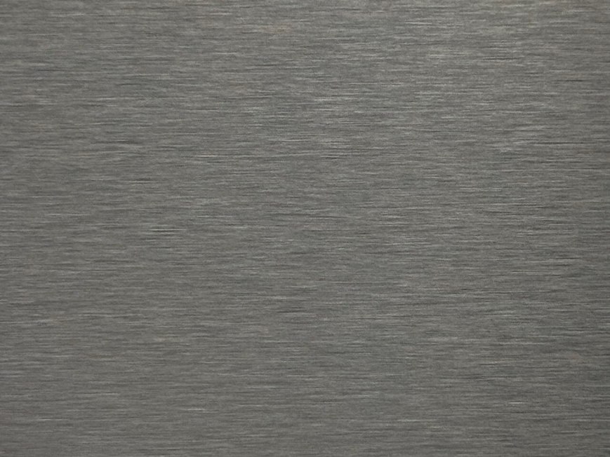 A silver satin stainless steel surface under soft diffused light where touch marks read with low contrast