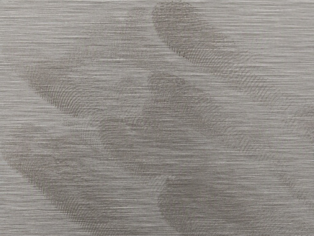 An extreme close-up of smeared fingerprint marks on a brushed stainless steel surface at short viewing distance
