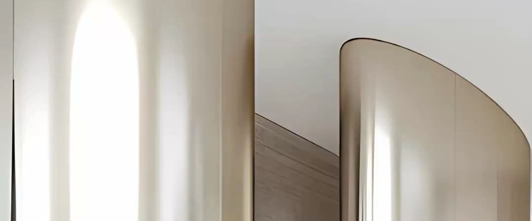 A large curved stainless steel wall surface in a bright interior