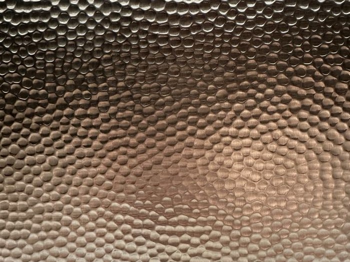 A project-specific fine hammered stainless steel surface developed to a custom colour direction