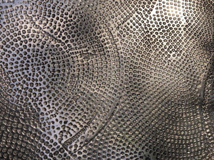 Dark grey hammered stainless steel direction shown under low-key light