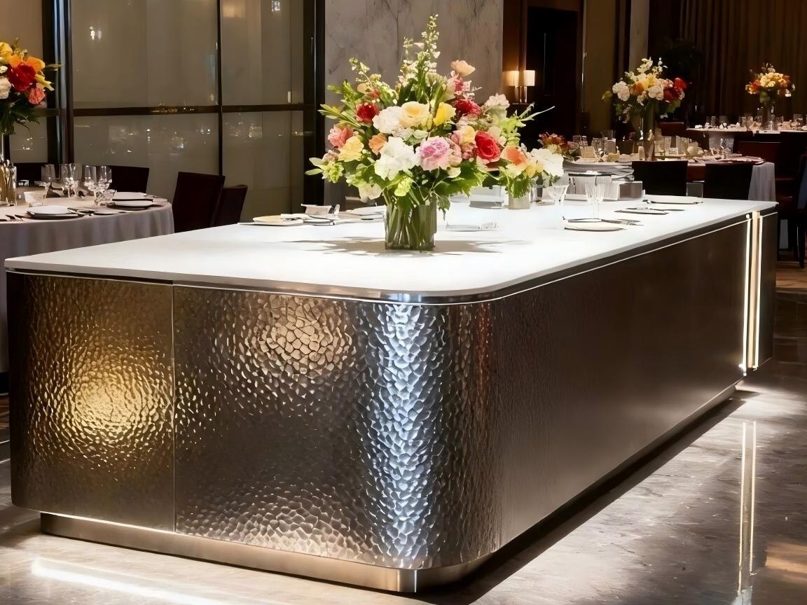 Hammered stainless steel lift doors and wall cladding seen at close range in a lobby