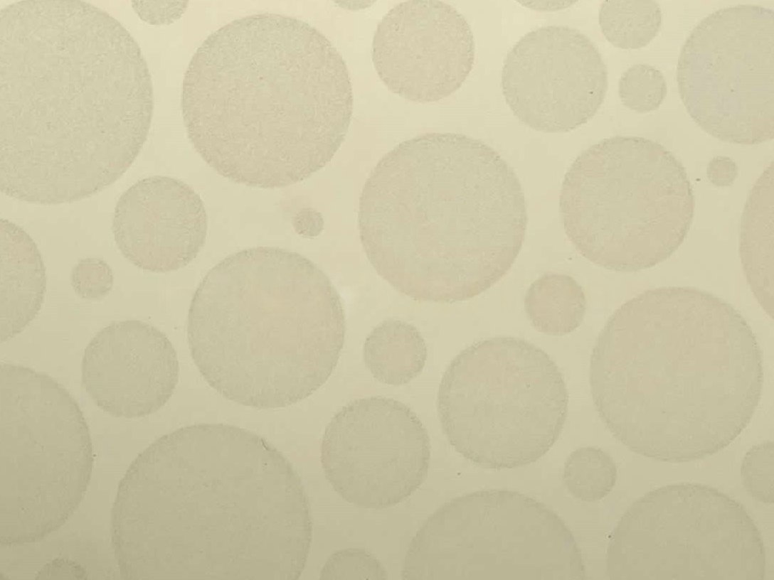 Etched stainless steel with low visual contrast where the pattern emerges softly across the surface