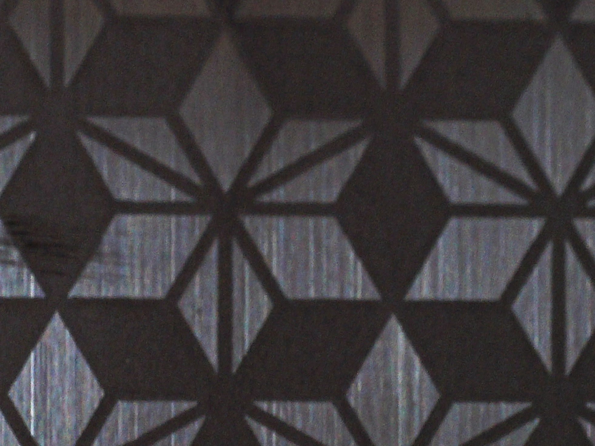 Dark titanium etched stainless steel creating deep contrast between the pattern and the ground