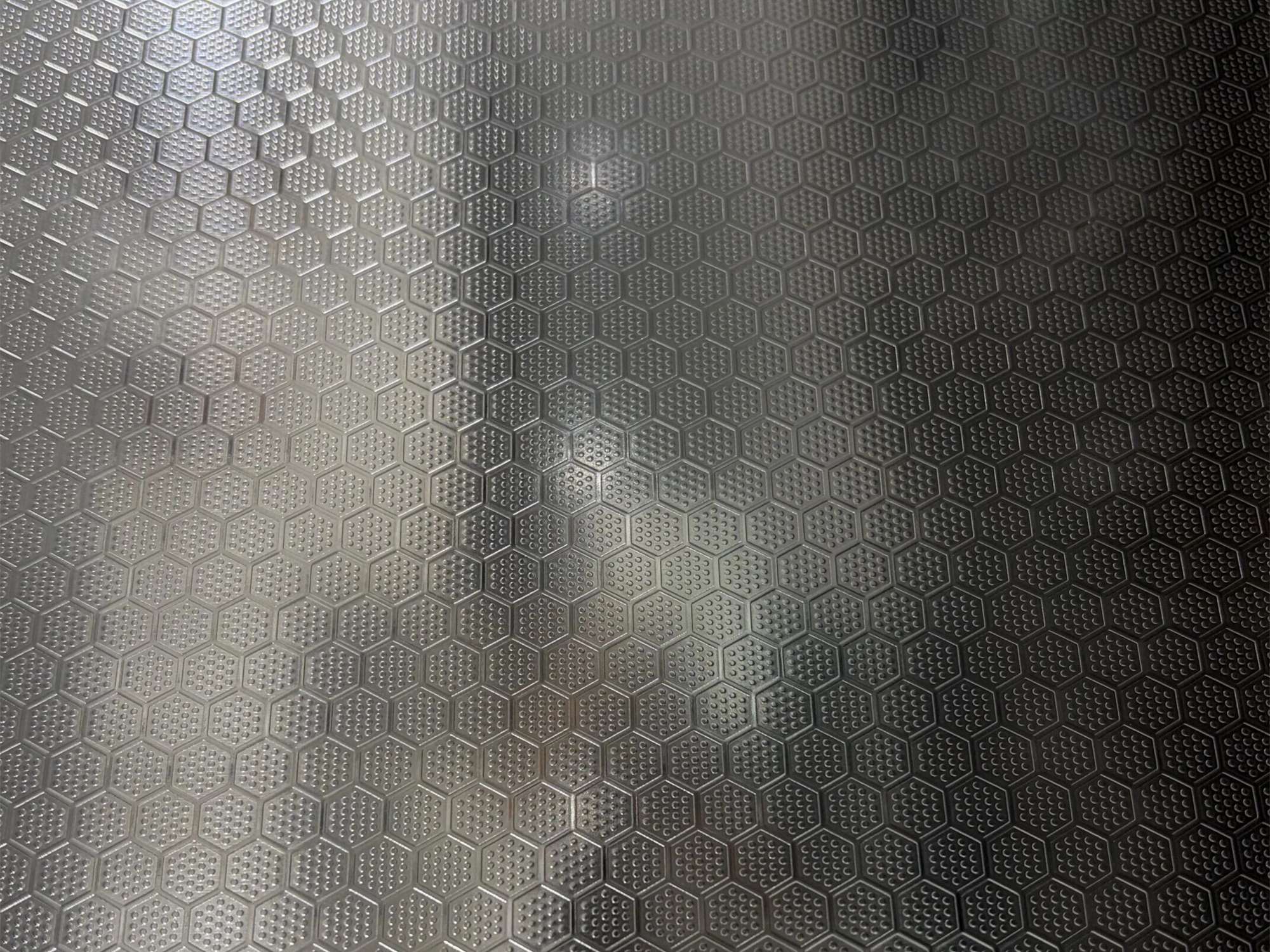 A physically embossed stainless steel surface where the pattern is created by dimensional relief